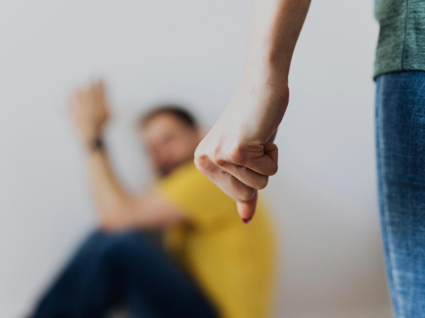 A woman forming a fist with in a threating manner