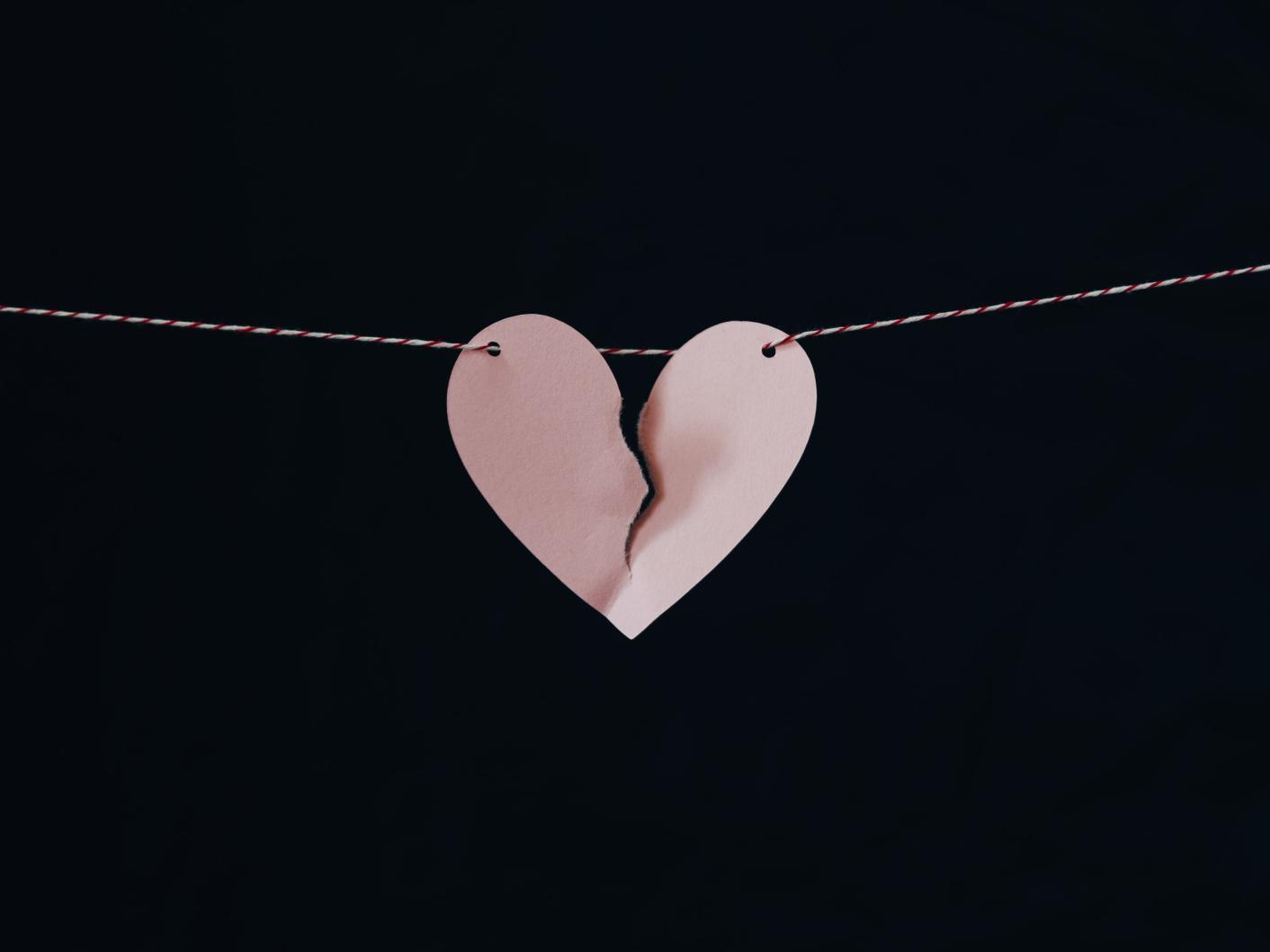 Broken paper heart hanging on a wire