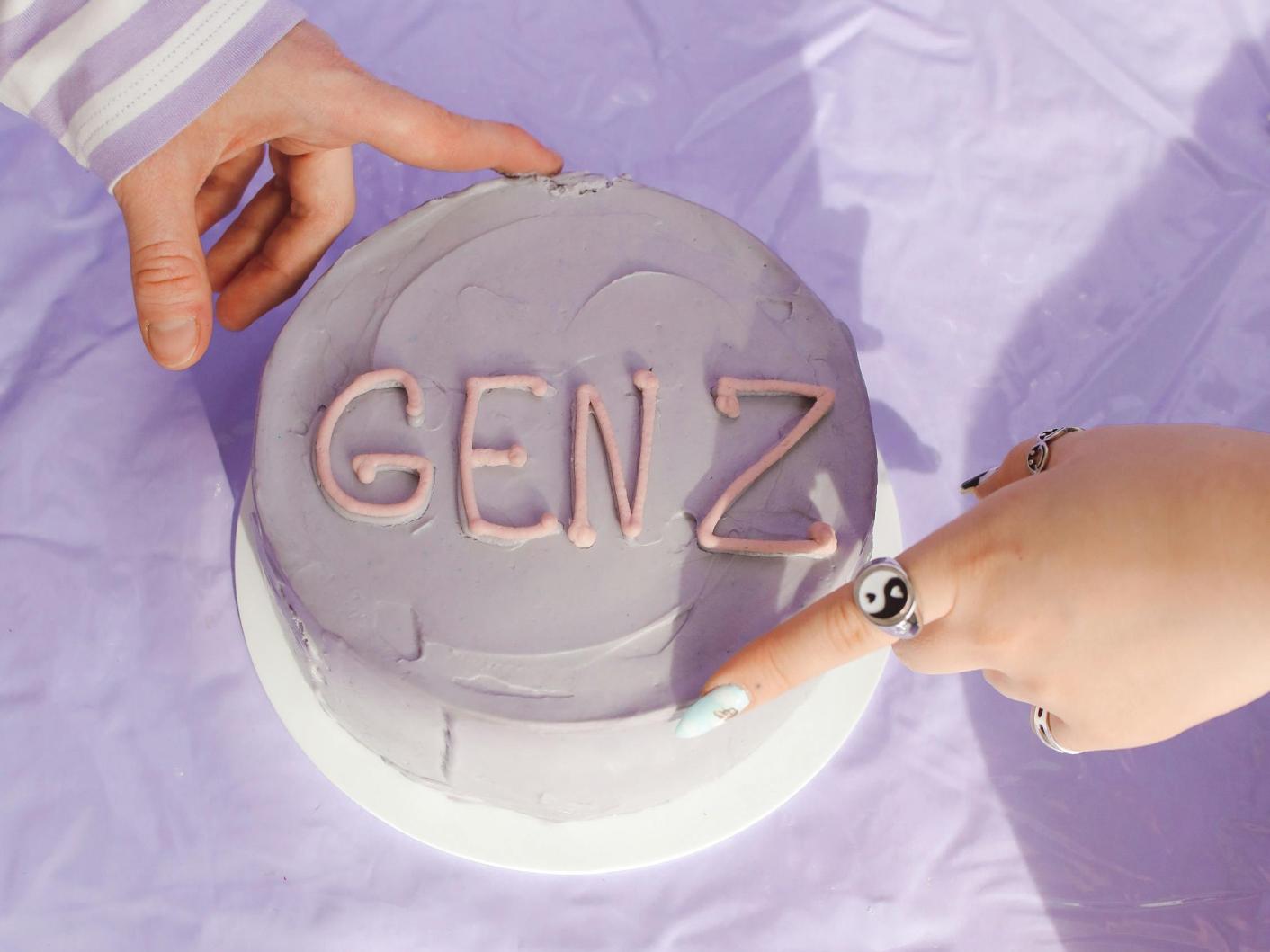 Photo of a cake showing GEN Z with two hands holding it