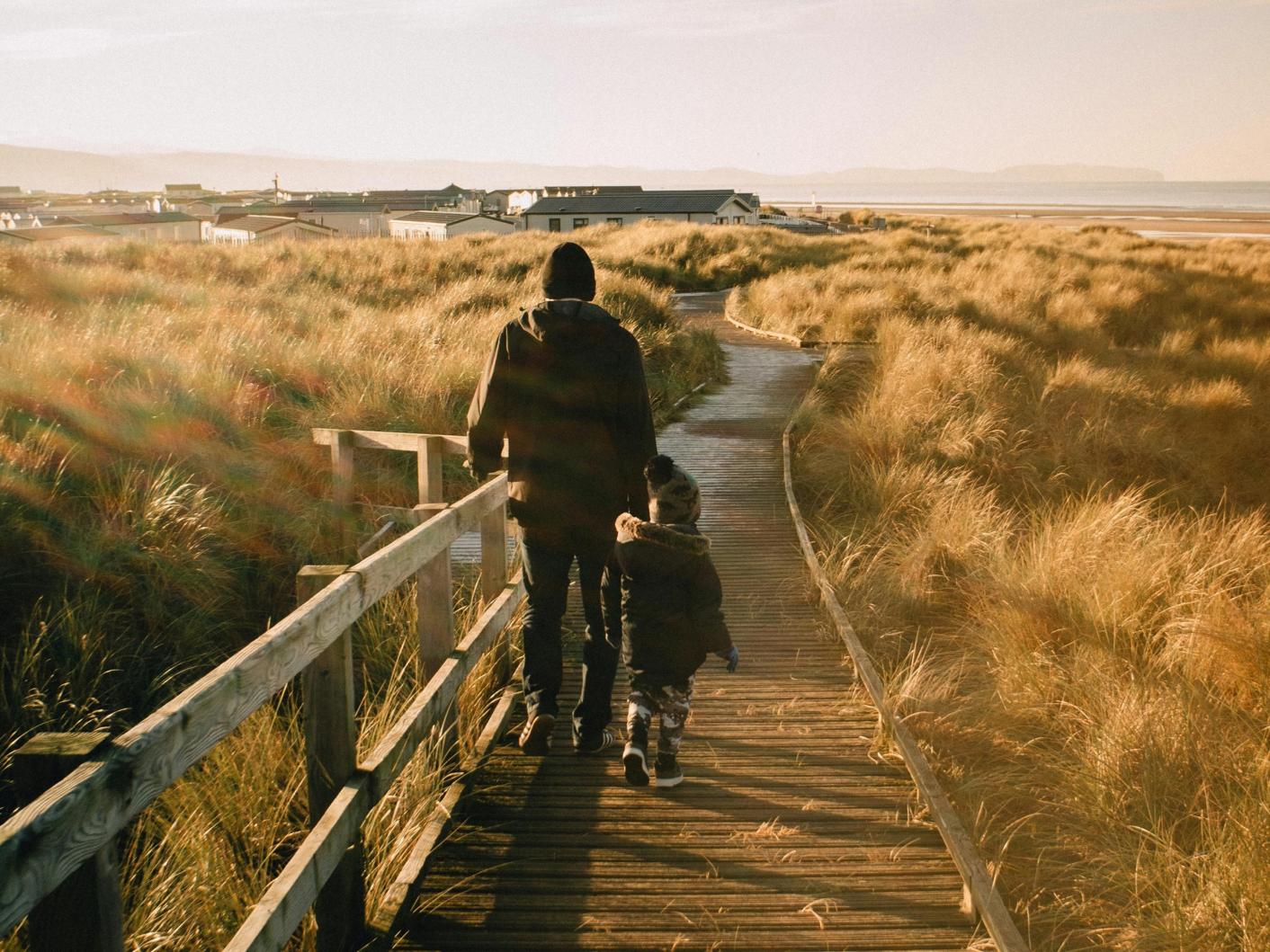 Father walking with small child on a pier