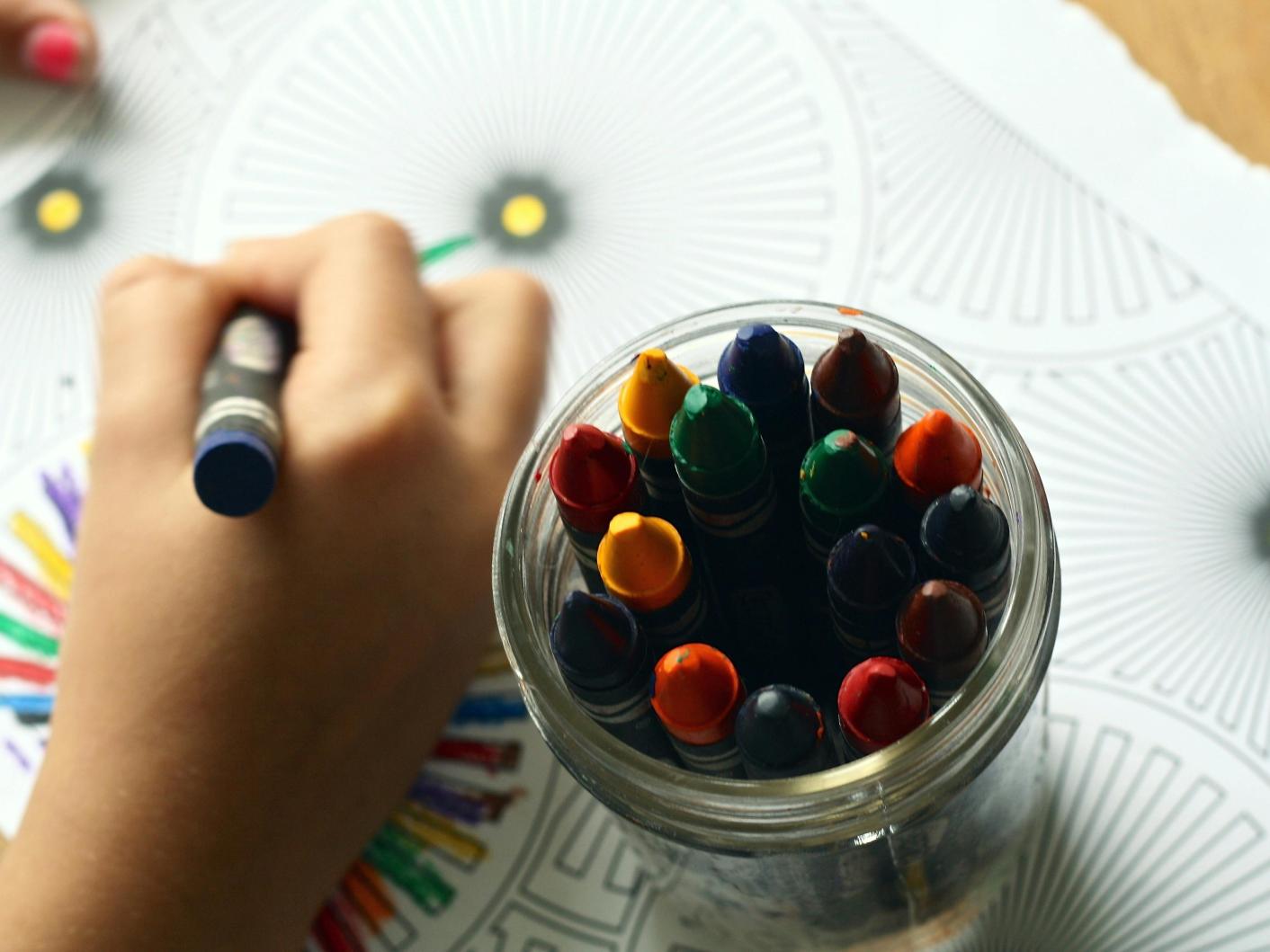 Child colouring art with crayons